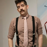 Clifford Packer, replica dildo. Man with mustache, taupe shirt, pink tie, black suspenders.